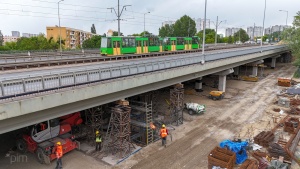 Prace budowlane pod wiaduktem - na wiadukcie jadący tramwaj
