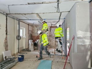 Pracownicy podczas prac wykończeniowych wewnątrz budynku