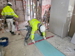 Pracownik podczas pracy z płytą gipsowo-kartonową