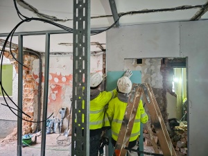 Pracownicy podczas prac wykończeniowych wewnątrz budynku