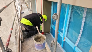 Pracownik podczas pracy przy ocieplaniu budynku