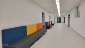 korytarz szkoły i kolorowe siedziska 
