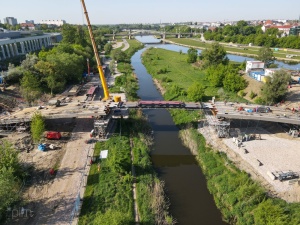 Żuraw podczas montażu elementów konstrukcyjnych mostu - widok z lotu ptaka 