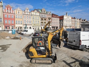 Koparka na placu budowy - kamienice rynkowe w tle