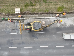 Układanie nowego krawężnika z pomocą sprzętu budowlanego