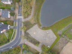 Plac serwisowy,ścieżka spacerowa i fragment zbiornika retencyjnego widziane z perspektywy lotu ptaka